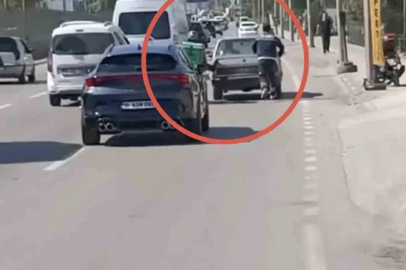 Bursa’da motokuryeden arızalanan otomobili itmek için ilginç yöntem

