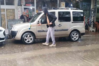 Sağanak yağışı fırsata çevirdi: Aracını yağmur altında yıkadı
