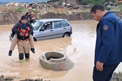 İtfaiyeci, göle dönen yolda mahsur kalan çocuğu sırtında taşıyarak kurtardı
