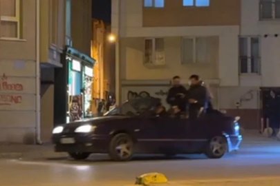 Seyir halindeki otomobillin bagajına ters oturan şahıs dikkat çekti
