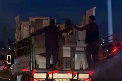 Kendi güvenliklerini değil, eşyaların güvenliğini sağlayarak kamyonetin arkasına tutundular
