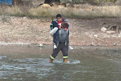 Köprü yıkılınca evladını her gün sırtında taşıyıp ırmaktan geçiriyor
