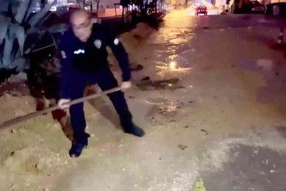 Araçlar zarar görmesin diye küreği eline alan polis memurları, suyla dolan çukurları toprakla doldurdular
